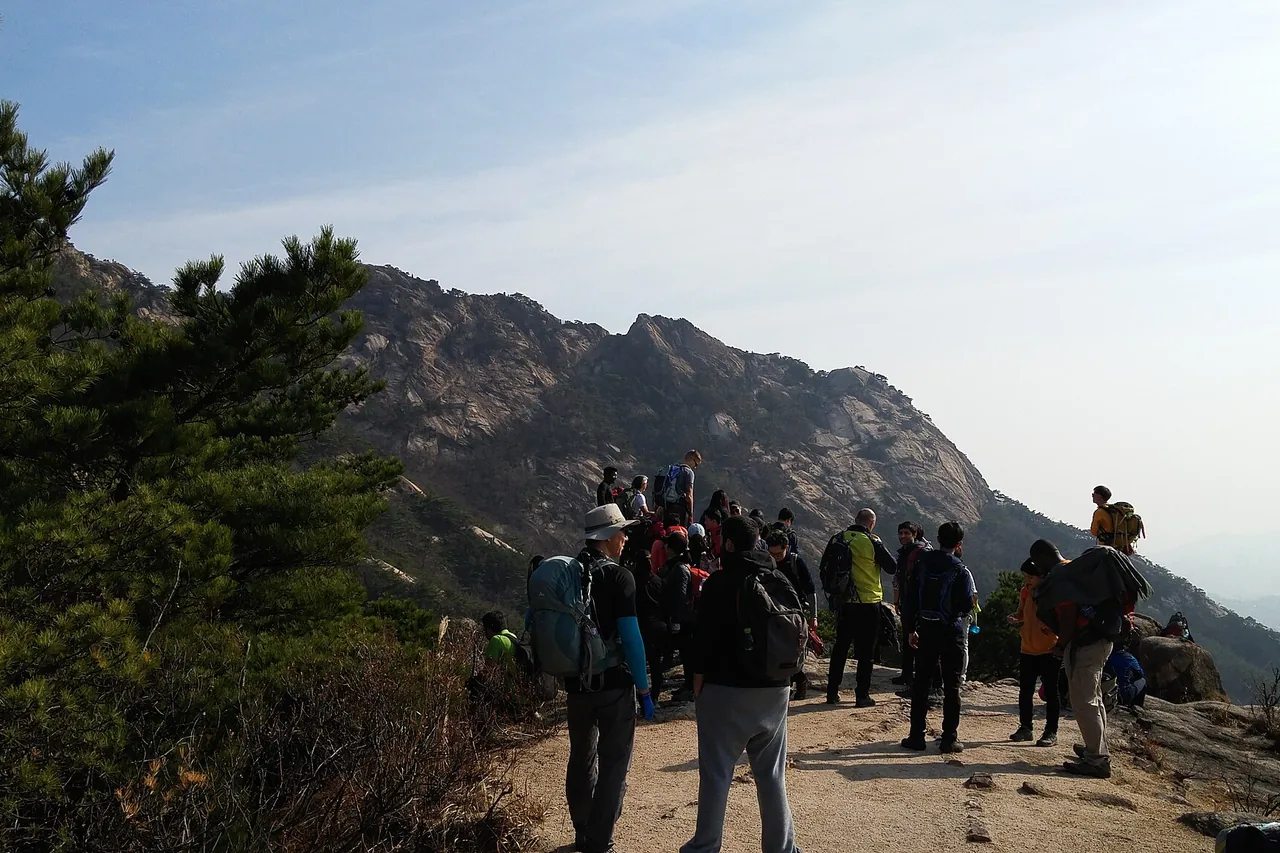 Hikers on the Bukhansan ridge below Baegundae with Seoul beyond
